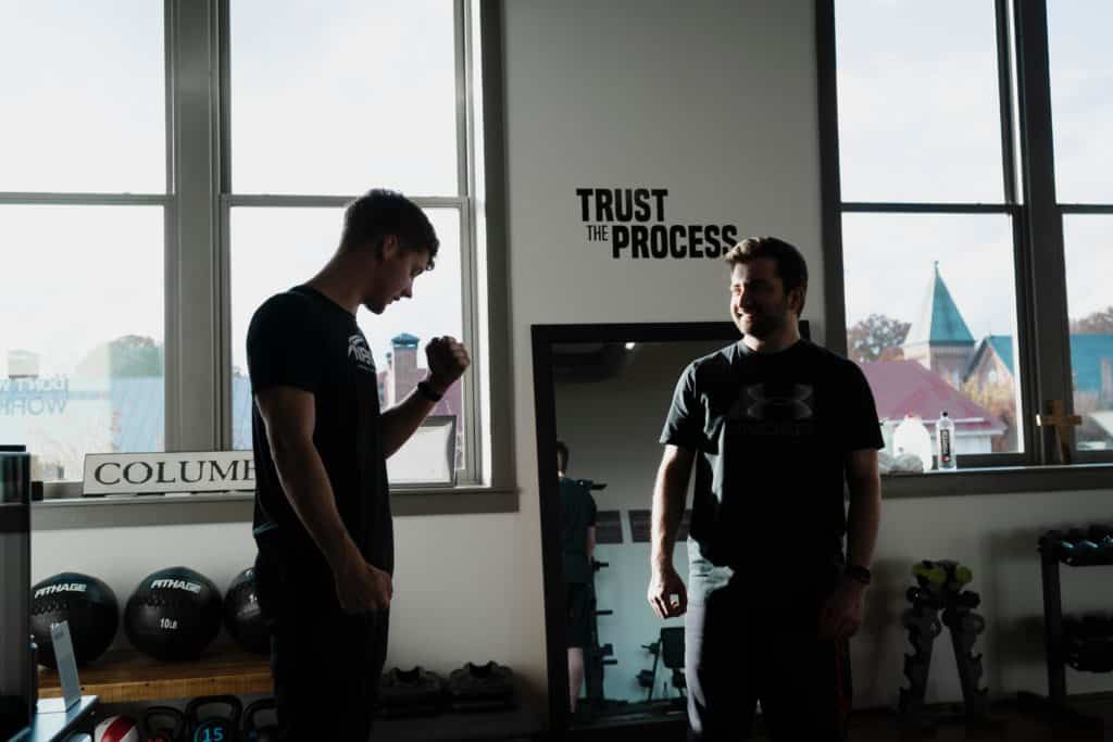 personal trainer with client in a gym